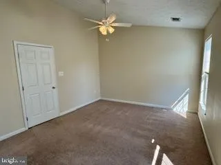 an empty room with a window and a fan