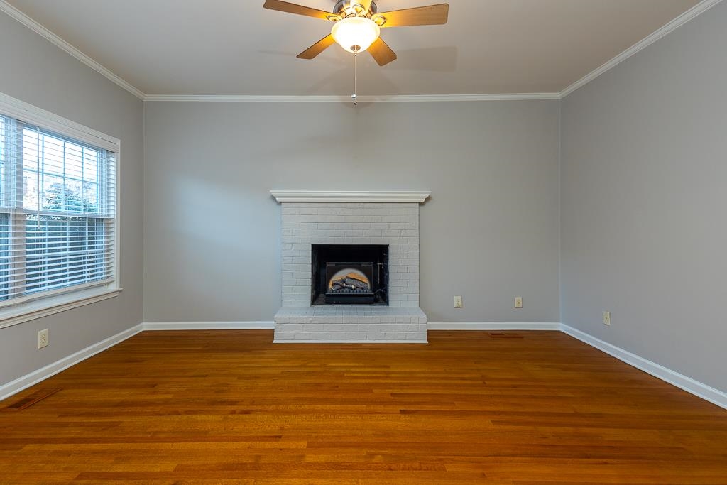 1806 Kimbrough Road Germantown, TN 38138 - Photo 5 of 26 a view of an empty room with wooden floor fireplace and a window