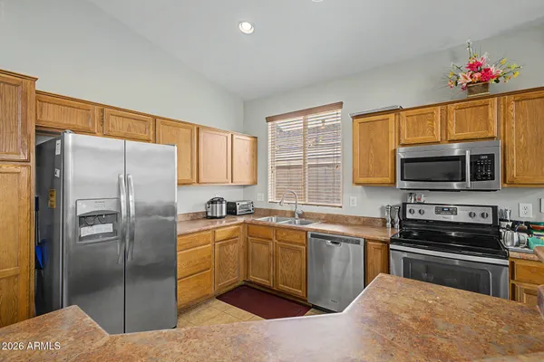a kitchen with stainless steel appliances kitchen island granite countertop a refrigerator stove and microwave