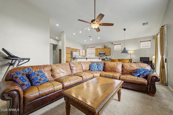 a living room with furniture kitchen view and a chandelier