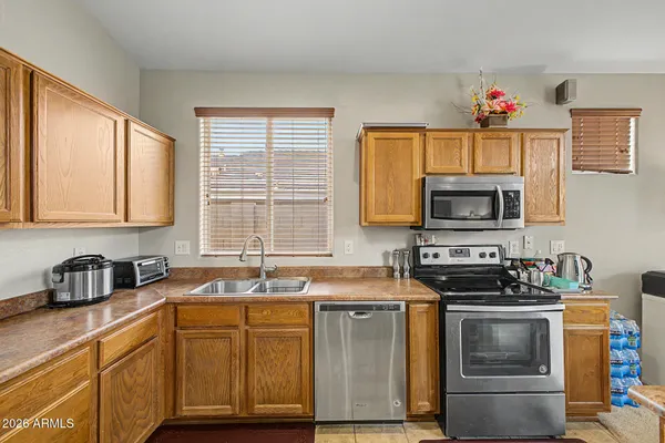 a kitchen with stainless steel appliances a stove sink microwave and window