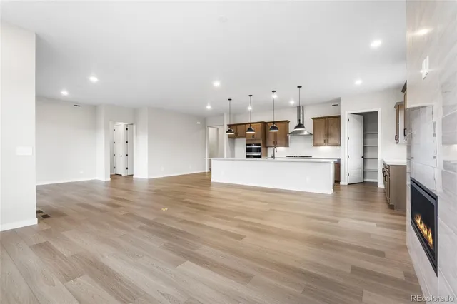 a view of a kitchen with kitchen island a sink stainless steel appliances and cabinets