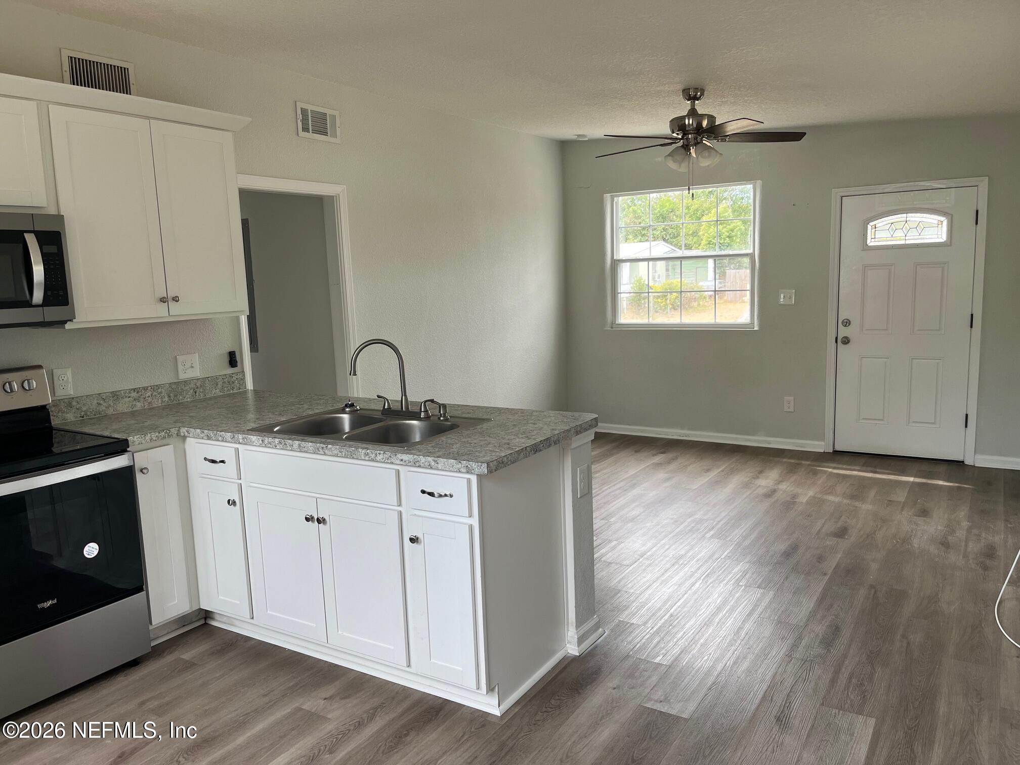 10547 Briarcliff Road East Jacksonville, FL 32218 - Photo 20 of 33 a kitchen with granite countertop a sink cabinets and wooden floor