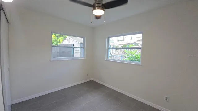 an empty room with window and fan