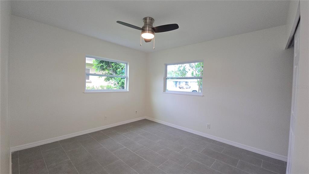 115 15th Avenue Southwest Largo, FL 33770 - Photo 8 of 13 an empty room with windows and ceiling fan