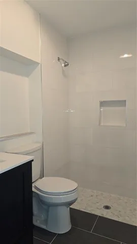 a white toilet sitting next to a shower