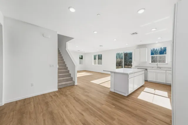 a view of living room with wooden floor and white appliances
