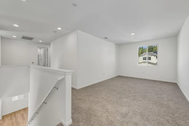 an empty room with a white wall & windows