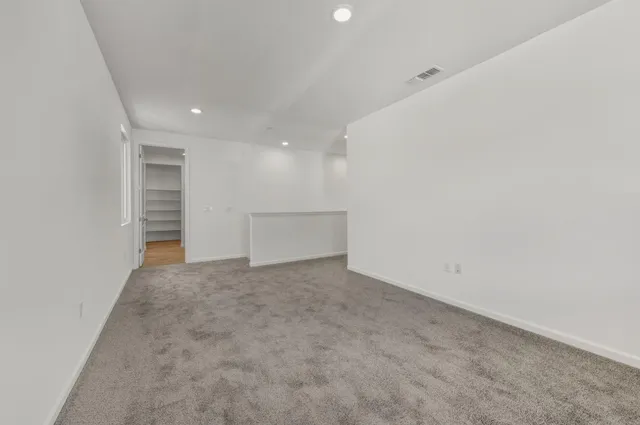 a view of an empty room with a kitchen
