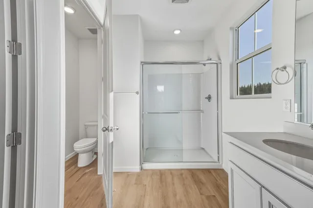 a bathroom with a sink a toilet and shower