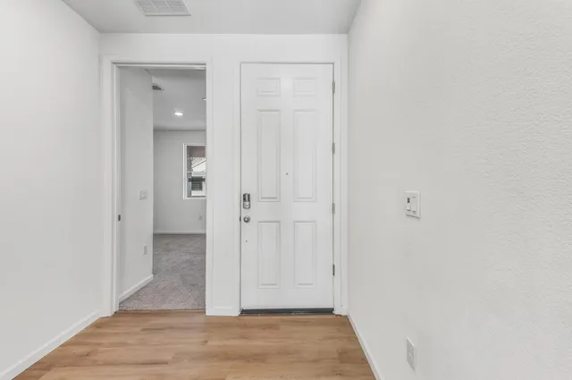 a view of a hallway with wooden floor