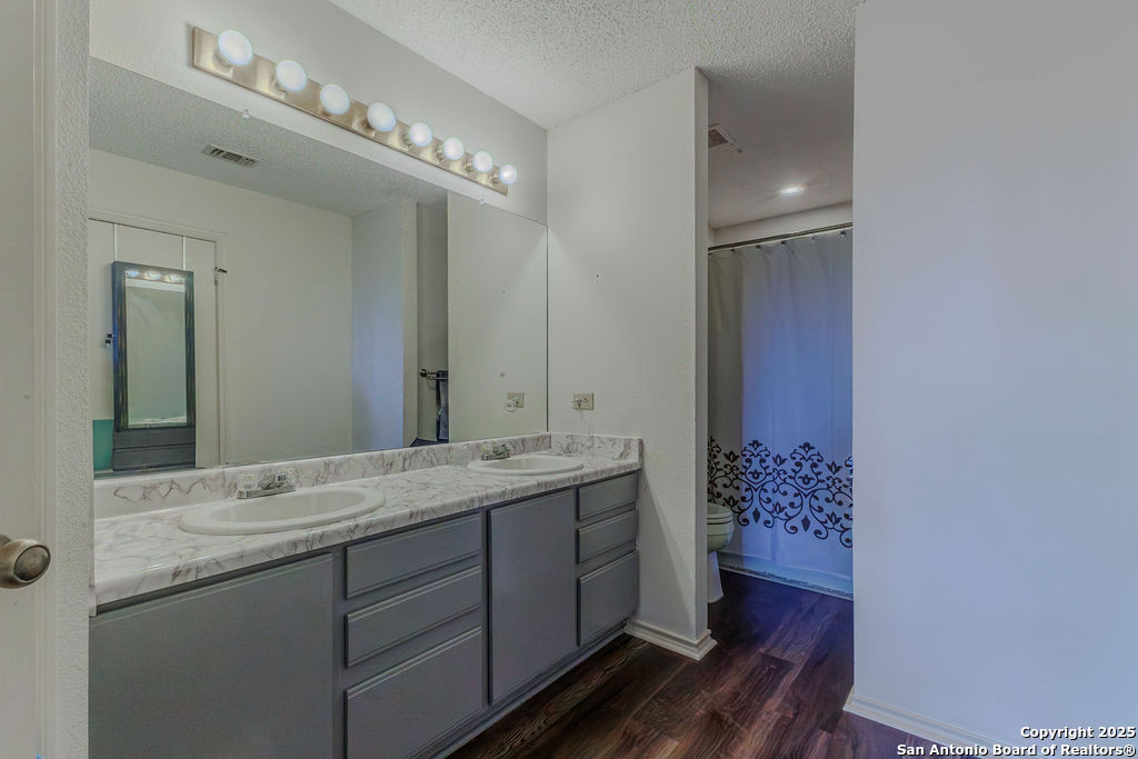 744 County Road 2651 Rio Medina, TX 78066 - Photo 14 of 27 a bathroom with a granite countertop sink toilet and mirror