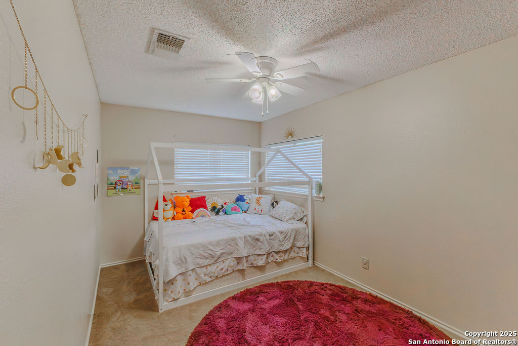 744 County Road 2651 Rio Medina, TX 78066 - Photo 17 of 27 a bedroom with a bed and a chandelier