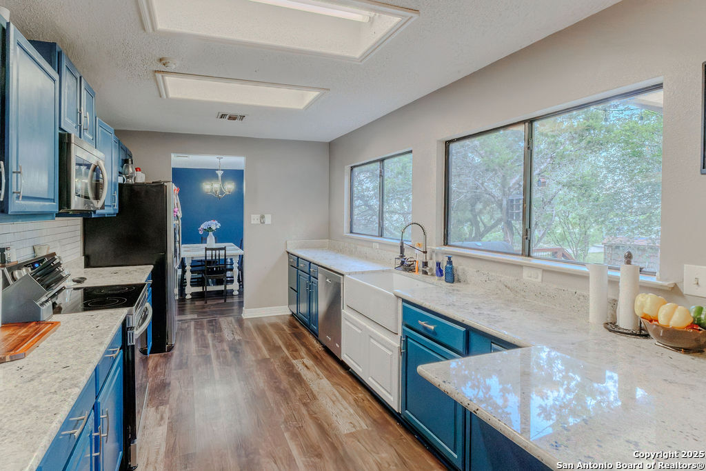 744 County Road 2651 Rio Medina, TX 78066 - Photo 8 of 27 a kitchen with sink cabinets and wooden floor