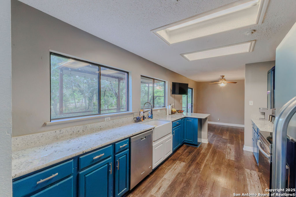 744 County Road 2651 Rio Medina, TX 78066 - Photo 9 of 27 a large kitchen with a sink and wooden floor