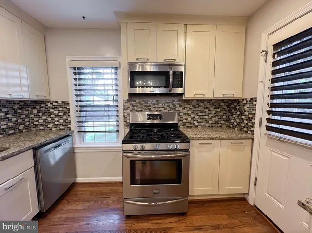 a kitchen with granite countertop a stove and a sink