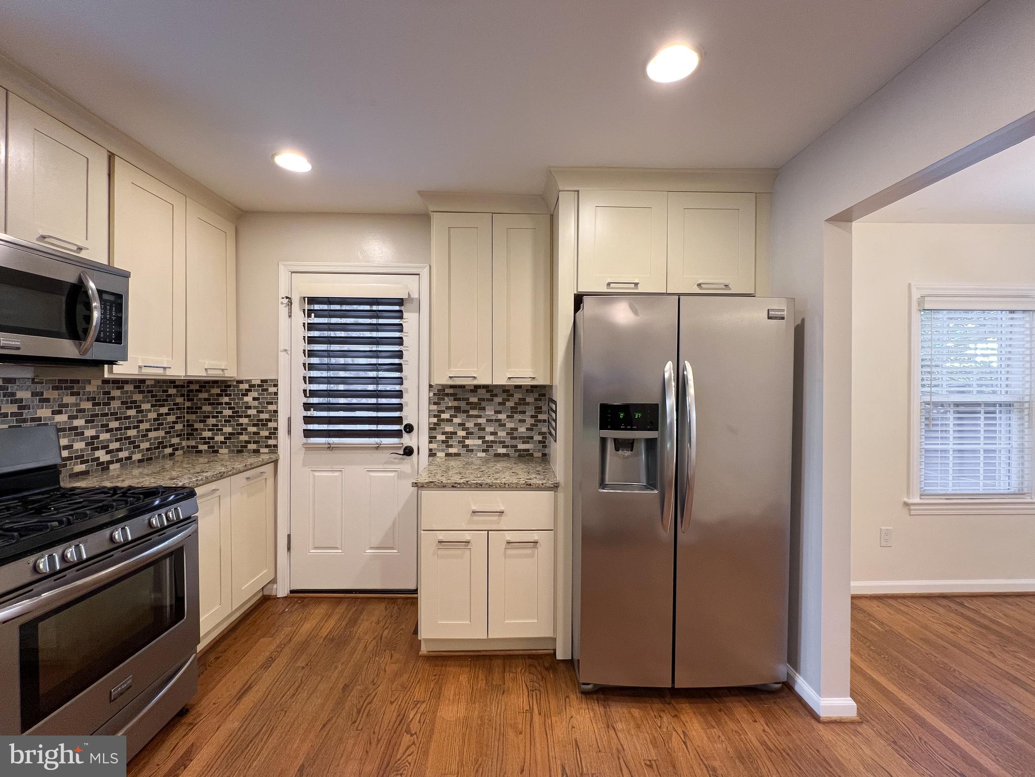 10159 Sutherland Road Silver Spring, MD 20901 - Photo 16 of 30 a kitchen with granite countertop a refrigerator and a stove top oven