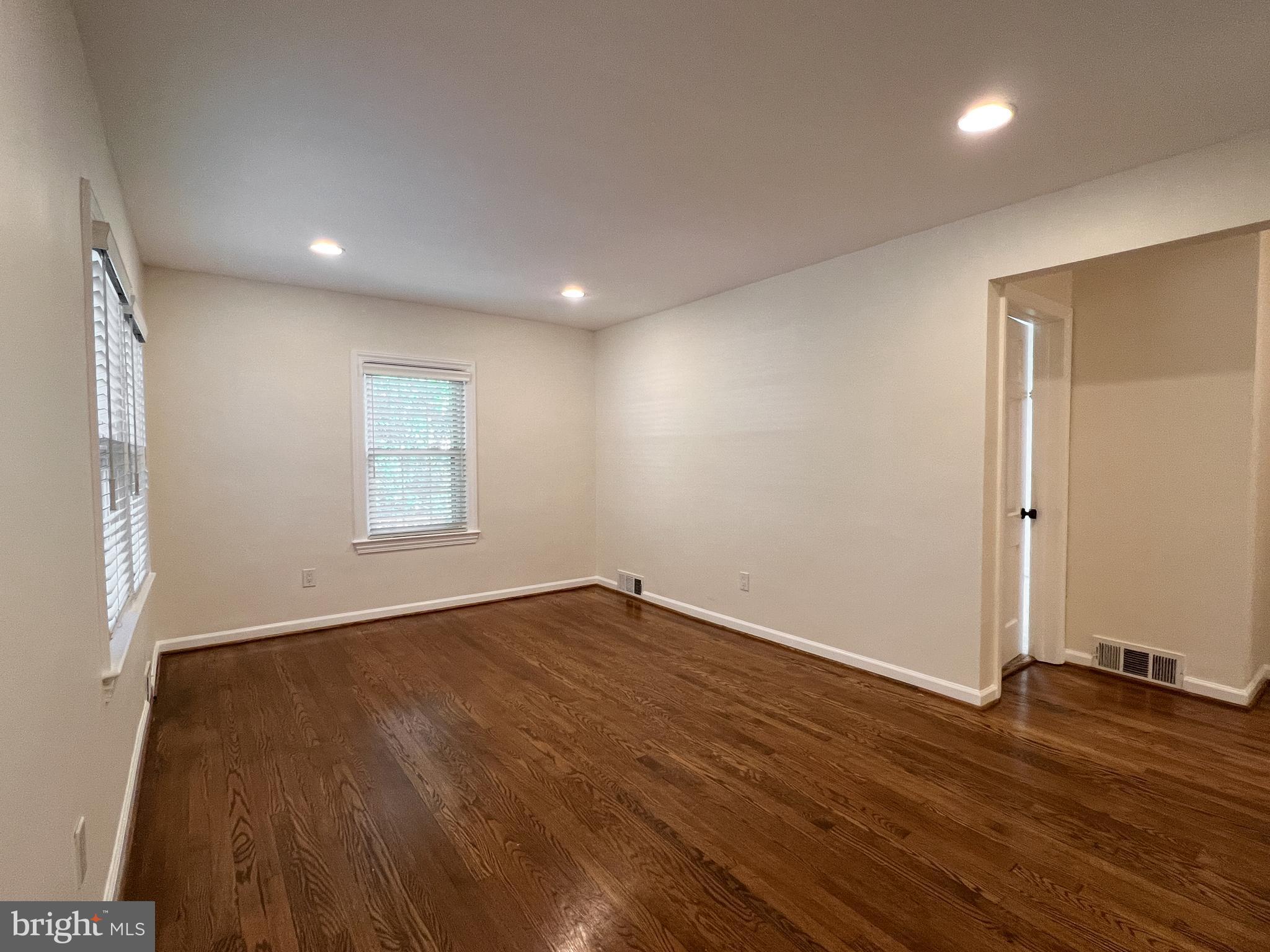 10159 Sutherland Road Silver Spring, MD 20901 - Photo 6 of 30 an empty room with wooden floor and windows