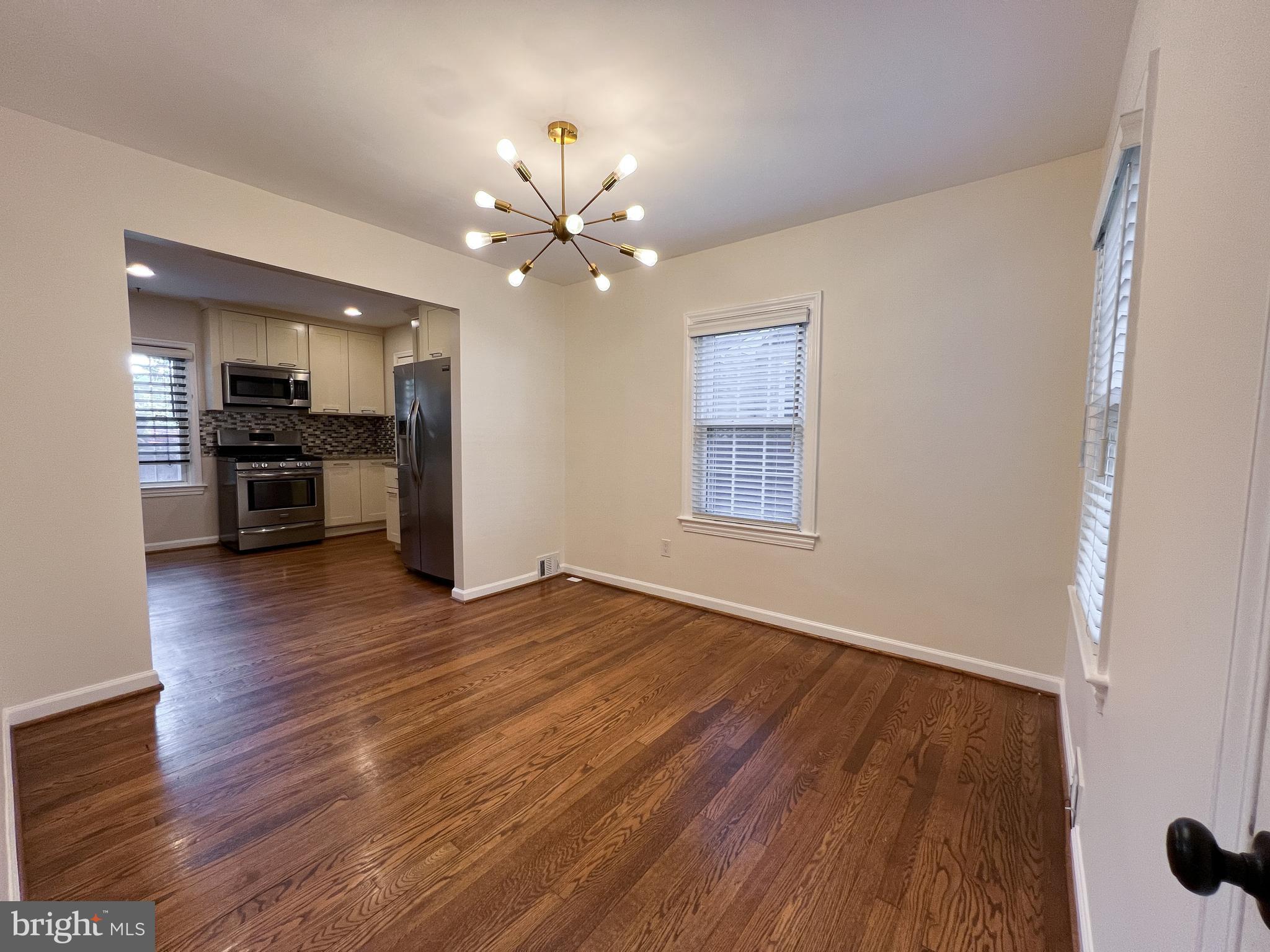 10159 Sutherland Road Silver Spring, MD 20901 - Photo 10 of 30 a view of an empty room with wooden floor and a window