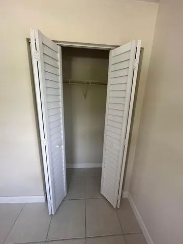 en empty room with windows and ceiling fan