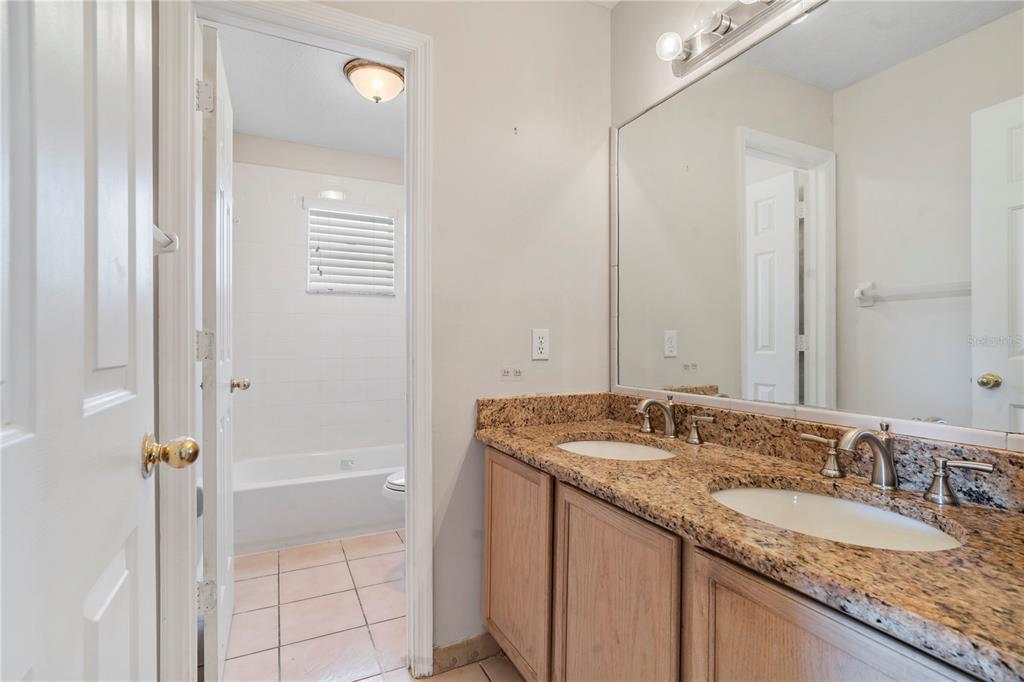565 Pinehurst Cove Kissimmee, FL 34758 - Photo 15 of 36 a bathroom with a granite countertop sink and a mirror