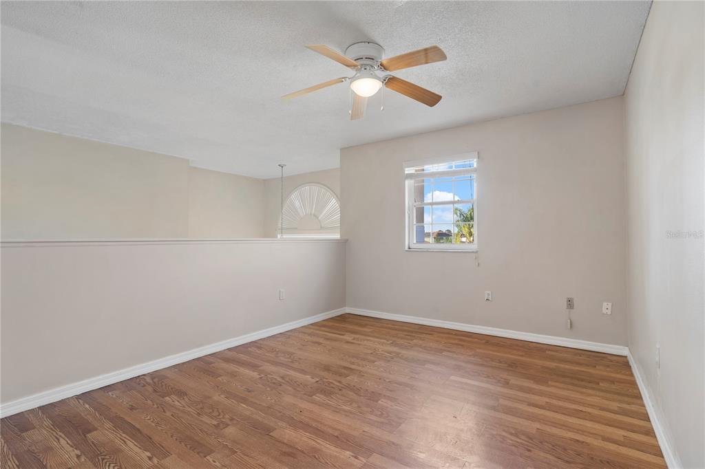 565 Pinehurst Cove Kissimmee, FL 34758 - Photo 16 of 36 an empty room with wooden floor and windows