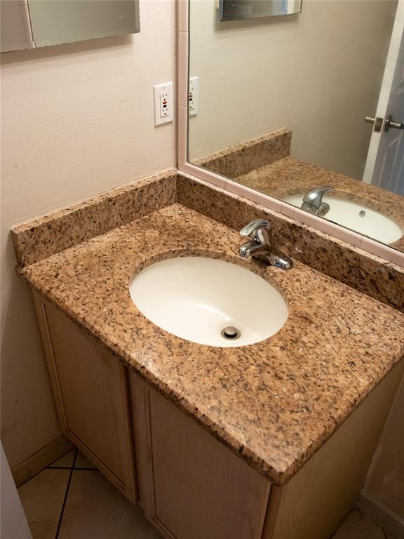 565 Pinehurst Cove Kissimmee, FL 34758 - Photo 4 of 36 a bathroom with a granite countertop sink and a mirror