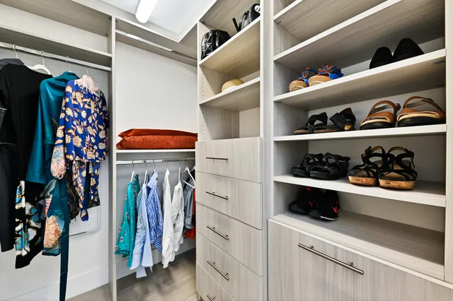 a view of walk in closet with clothes and shoes