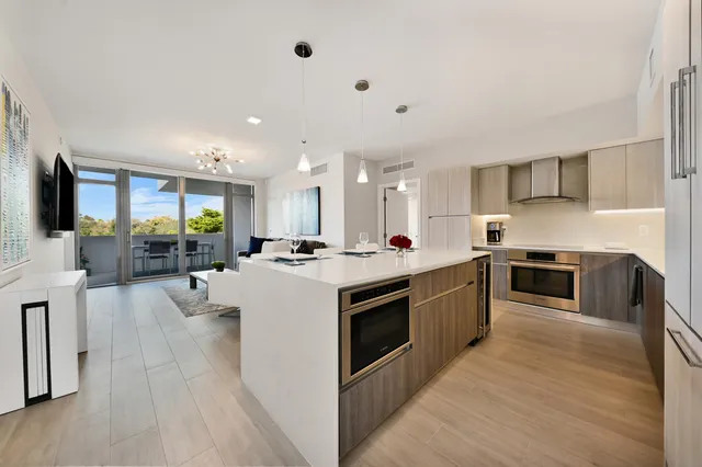 a large kitchen with stainless steel appliances lots of counter space and wooden floor