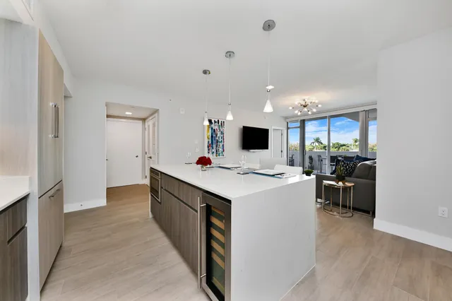 a view of a kitchen with kitchen island a sink a stove and a refrigerator