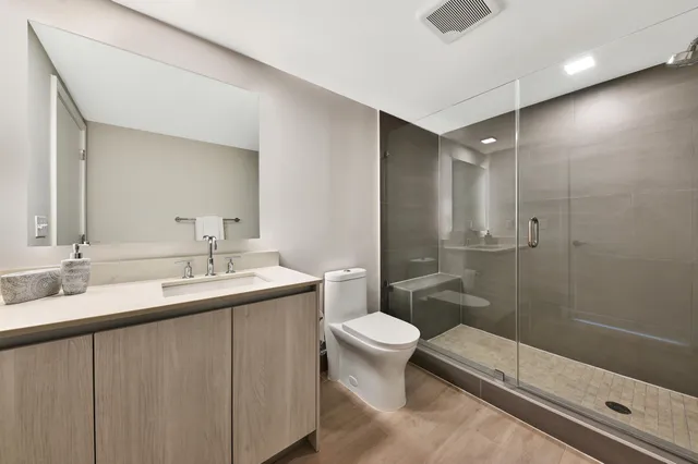 a bathroom with a sink a toilet and shower