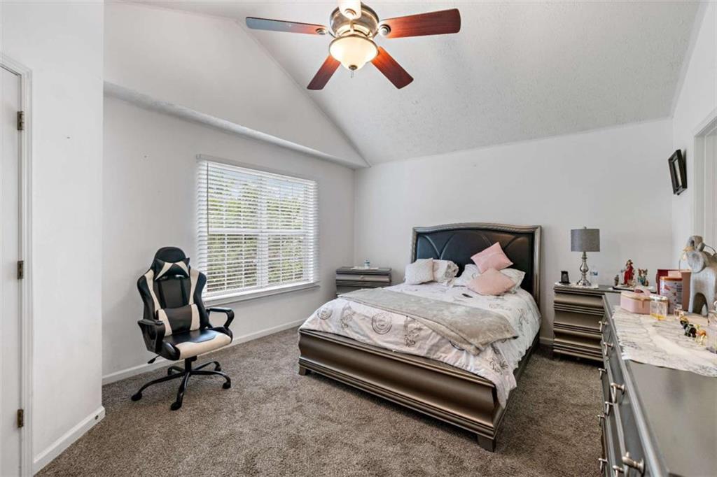 248 Springbottom Drive Southeast Lawrenceville, GA 30046 - Photo 22 of 32 a bedroom with a bed a chair and a chandelier