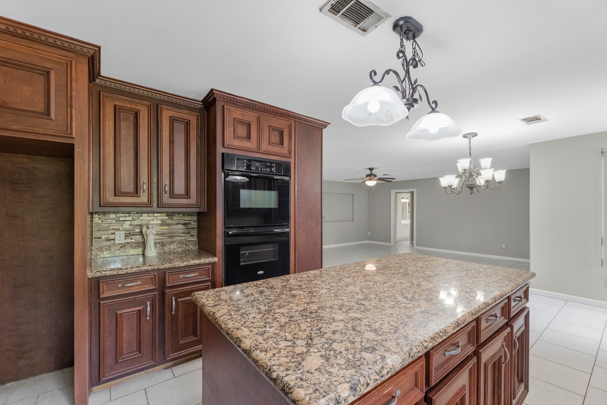 1109 Becker Street Channelview, TX 77530 - Photo 16 of 49 a kitchen with kitchen island granite countertop wooden cabinets and chandelier