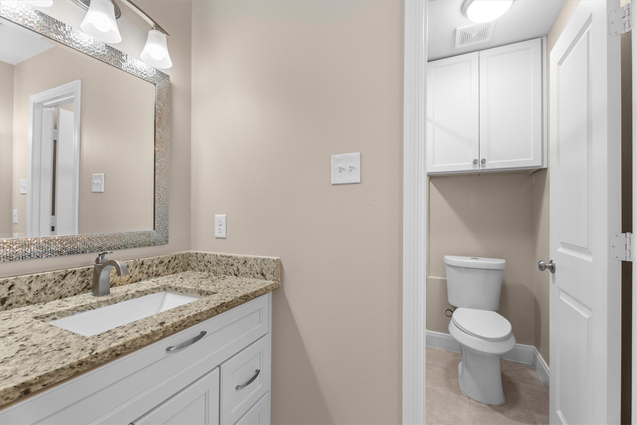 6530 Bayonne Drive Spring, TX 77389 - Photo 29 of 37 a bathroom with a granite countertop sink a toilet and a mirror