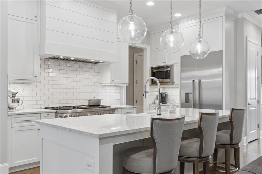 317 Riversedge Drive Atlanta, GA 30339 - Photo 14 of 68 a kitchen with a dining table chairs cabinets and stainless steel appliances
