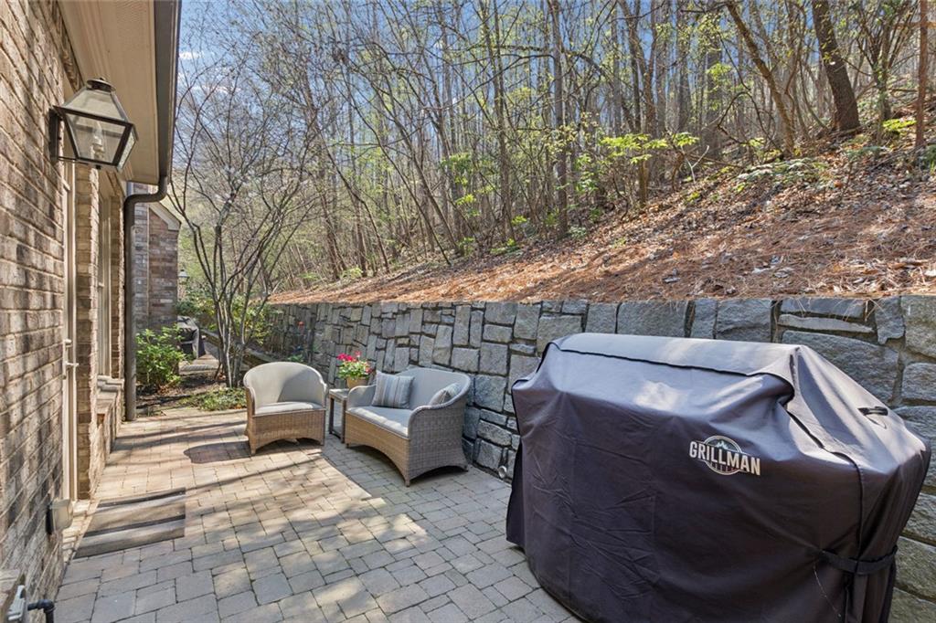 317 Riversedge Drive Atlanta, GA 30339 - Photo 25 of 68 a view of a patio with table and chairs couches under an umbrella with large trees