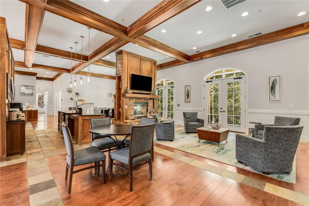 317 Riversedge Drive Atlanta, GA 30339 - Photo 52 of 68 a dining room with wooden floor a chandelier a glass table and chairs