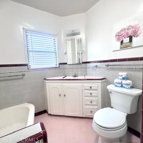 a bathroom with a granite countertop toilet sink and mirror