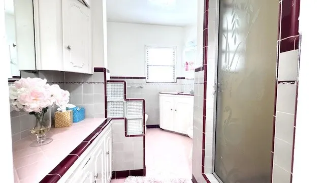 a kitchen with white cabinets and sink