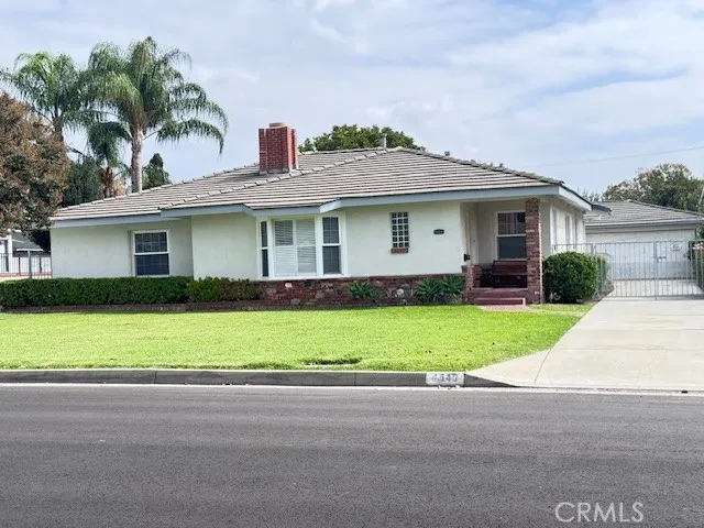 a front view of a house with a garden and plants