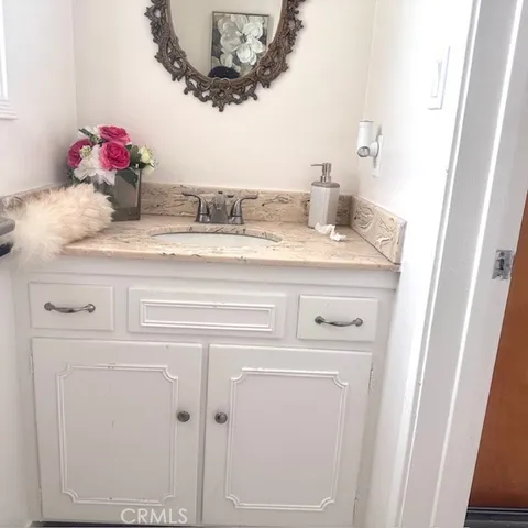 a bathroom with a granite countertop sink and a mirror