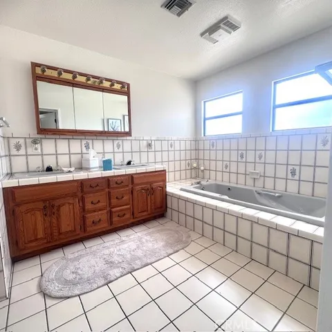 a large bathroom with a large tub sink shower and mirror