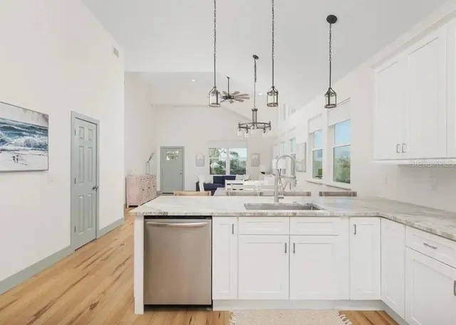 a kitchen with kitchen island white cabinets and white appliances