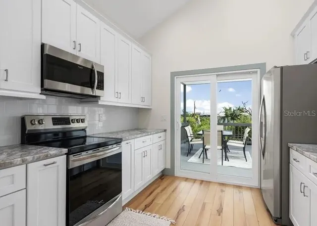 a kitchen with stainless steel appliances a stove a sink and a microwave