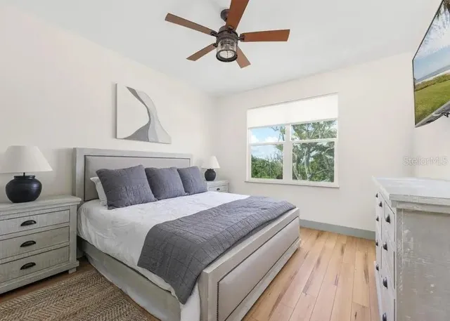 a bedroom with a bed and a flat tv screen on dresser