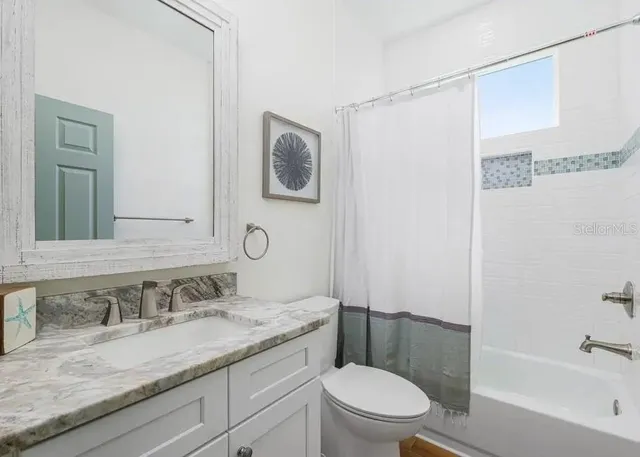 a bathroom with a granite countertop sink toilet and shower