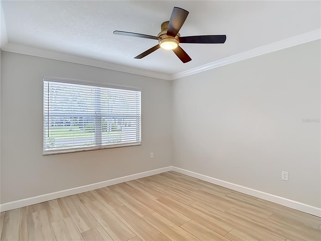 4536 Mitcher Road New Port Richey, FL 34652 - Photo 21 of 46 a view of empty room with wooden floor and fan
