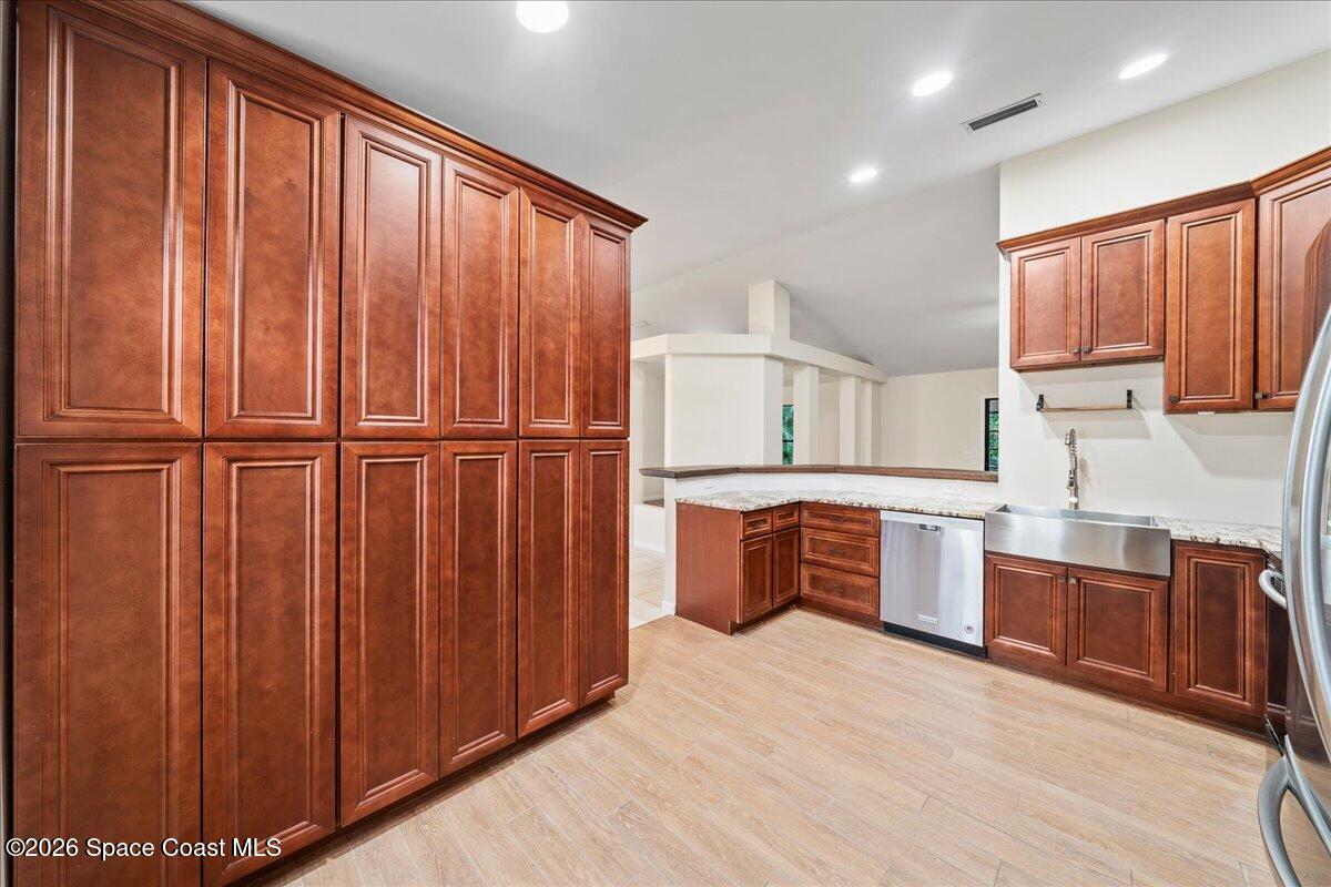 189 Abeto Terrace Sebastian, FL 32958 - Photo 11 of 38 a large kitchen with stainless steel appliances wooden cabinets a stove top oven