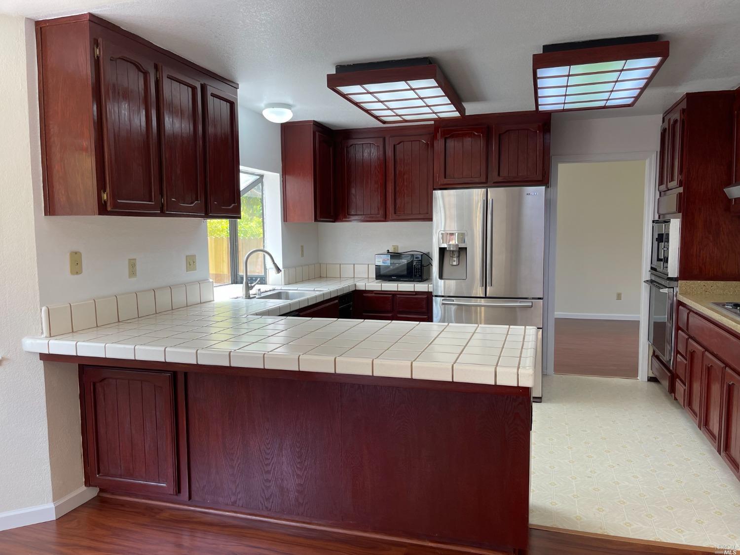 431 Darley Drive Vallejo, CA 94591 - Photo 6 of 27 a kitchen with kitchen island granite countertop wooden cabinets a refrigerator and a sink