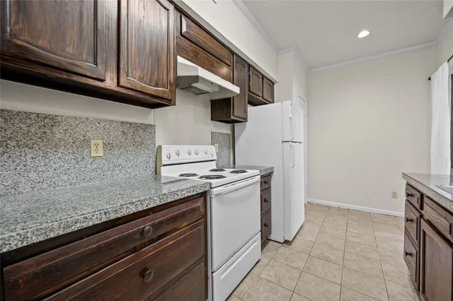a kitchen with stainless steel appliances granite countertop a refrigerator and a stove
